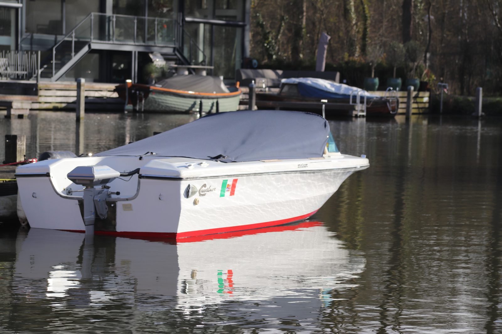 Een naar elektrisch omgebouwde sloep ligt afgemeerd voor een Amsterdamse gracht