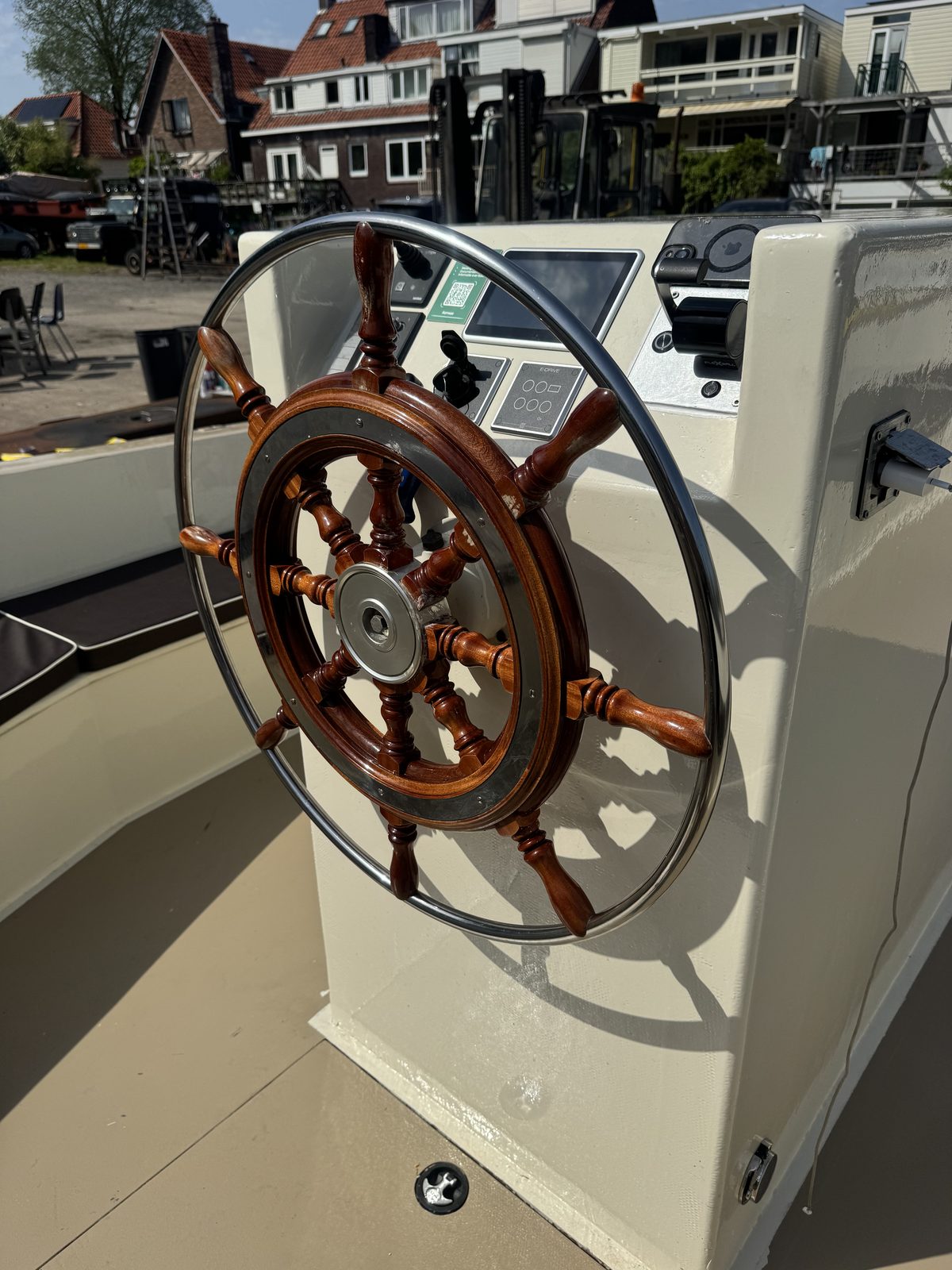 Origineel houten stuurwiel met stalen rand op een omgebouwde boot
