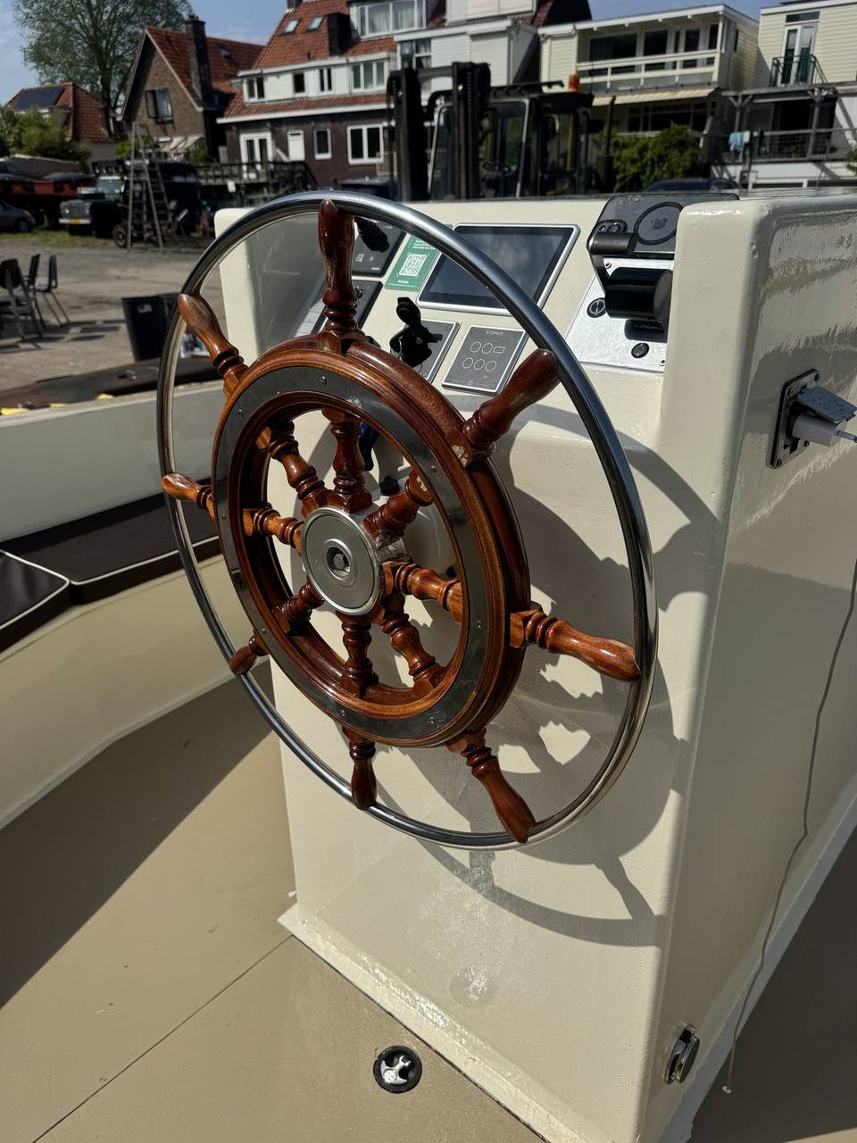 Origineel houten stuurwiel met stalen rand op een omgebouwde boot