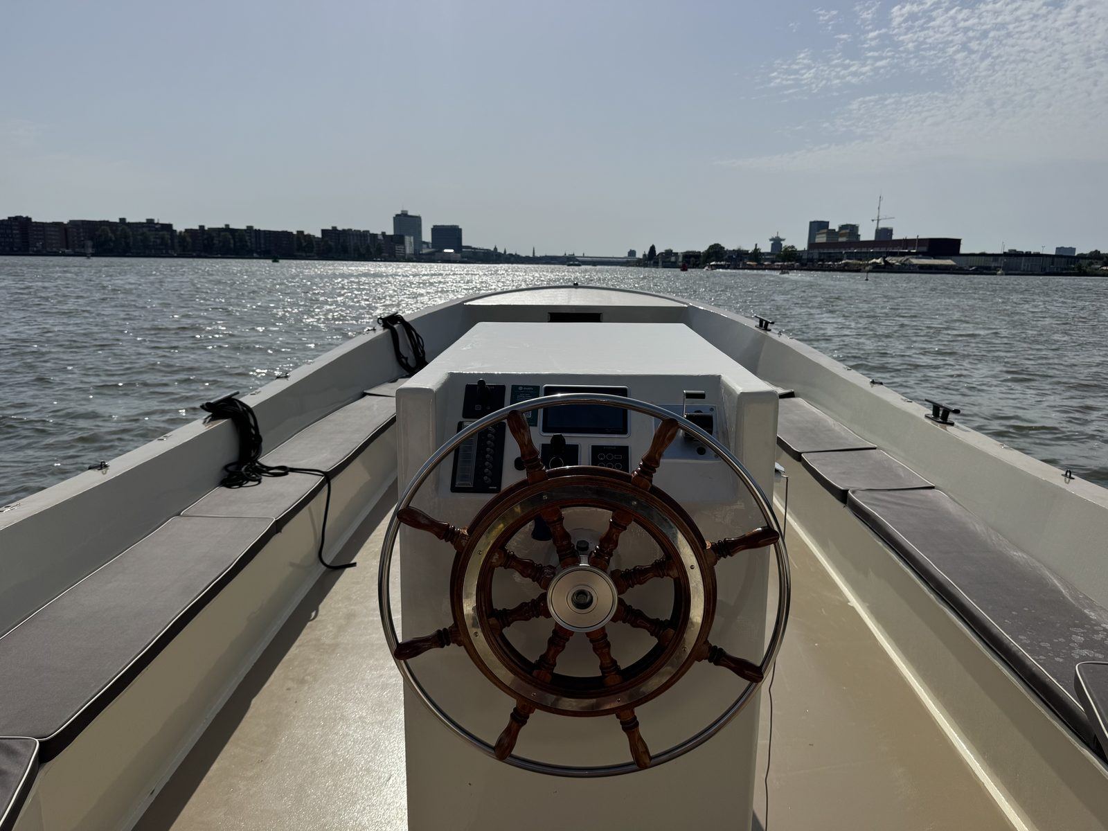 Elektrisch varen over het IJ in Amsterdam met klassiek houten stuurwiel