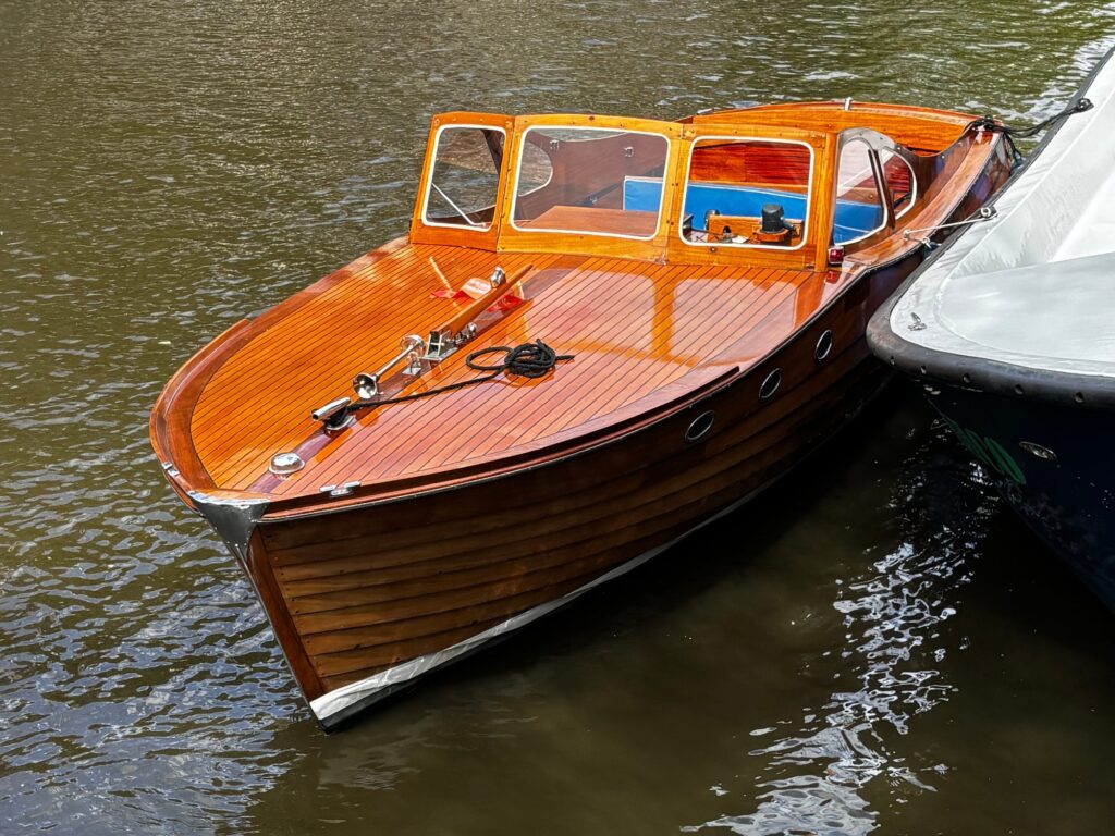 Klassieke mahoniehouten Storebro Solö Ruff uit 1955, elektrisch omgebouwd, afgemeerd in een Amsterdamse gracht